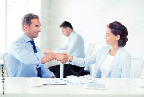 man and woman shaking hands in office