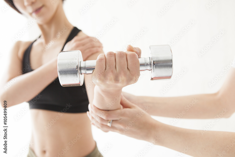 Women are trained to arms in the dumbbell with trainer Women are trained to arms in the dumbbell with trainer