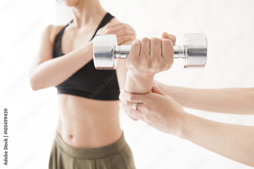 Women are trained to arms in the dumbbell with trainer Women are trained to arms in the dumbbell with trainer
