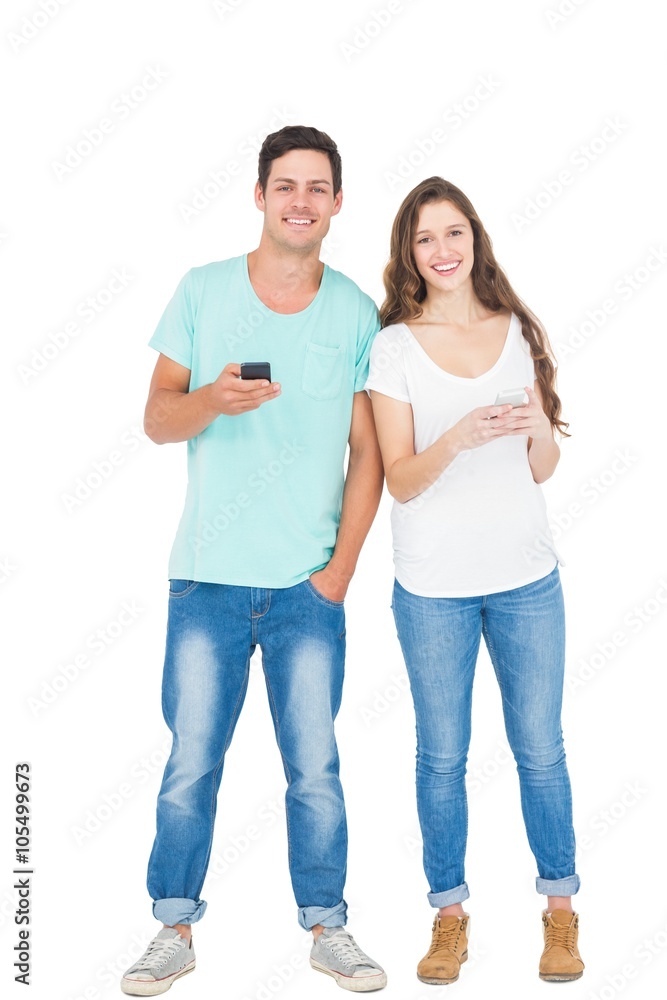 Smiling couple using their smartphones Smiling couple using their smartphones