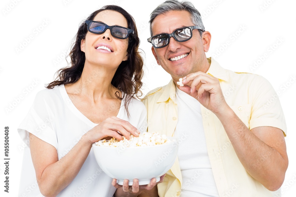 Smiling couple with 3D glasses eating popcorn Smiling couple with 3D glasses eating popcorn