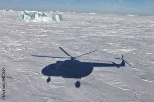 Fototapeta Naklejka Na Ścianę i Meble -  Aerial view of iceberg in frozen Arctic Ocean and helicopter shadow