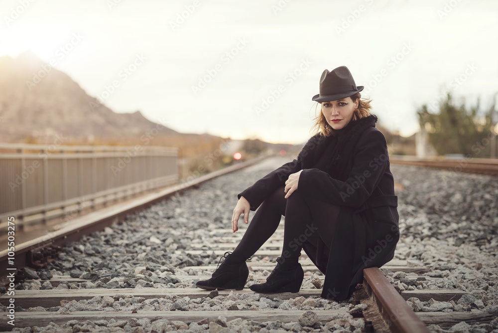 mujer joven sentada en las vías del tren mujer joven sentada en las vías del tren