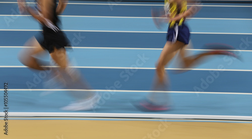 Blured athletes run in track and field