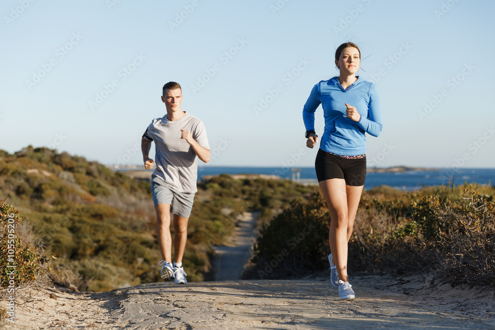 Fototapeta premium Sport runner jogging on beach working out with her partner