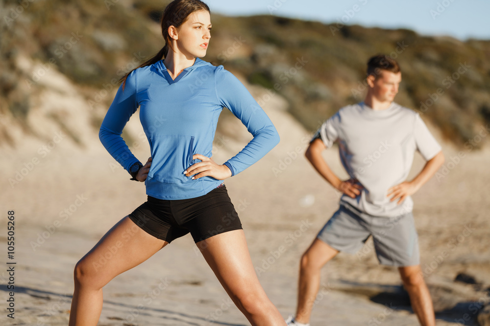 Young couple on beach training together