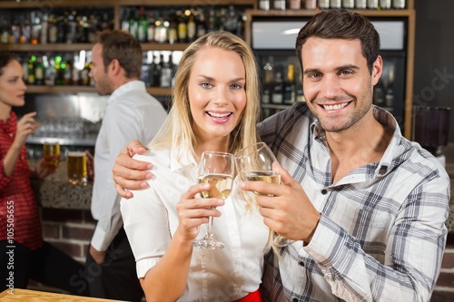 Couple smiling at camera and toasting