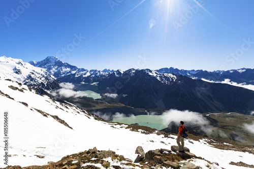Hiker on top of mountain looking at Mount Cook
