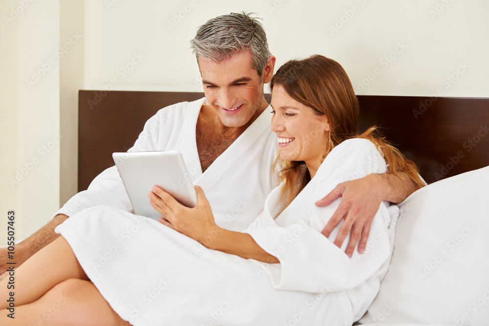Paar im Hotel schaut auf Tablet Computer Paar im Hotel schaut auf Tablet Computer