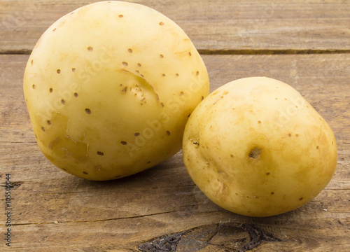 Two imperfect potatoes on rustic wood table