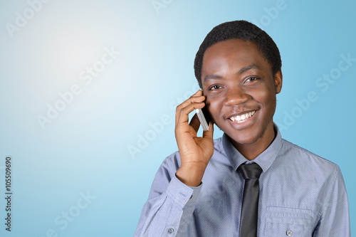 Portrait of a happy young african man with a mobile phone