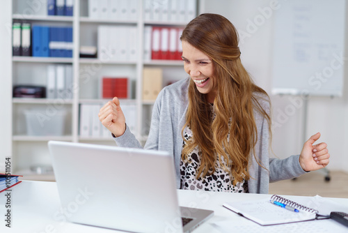 Photos frau im büro ballt lachend die fäuste und jubel