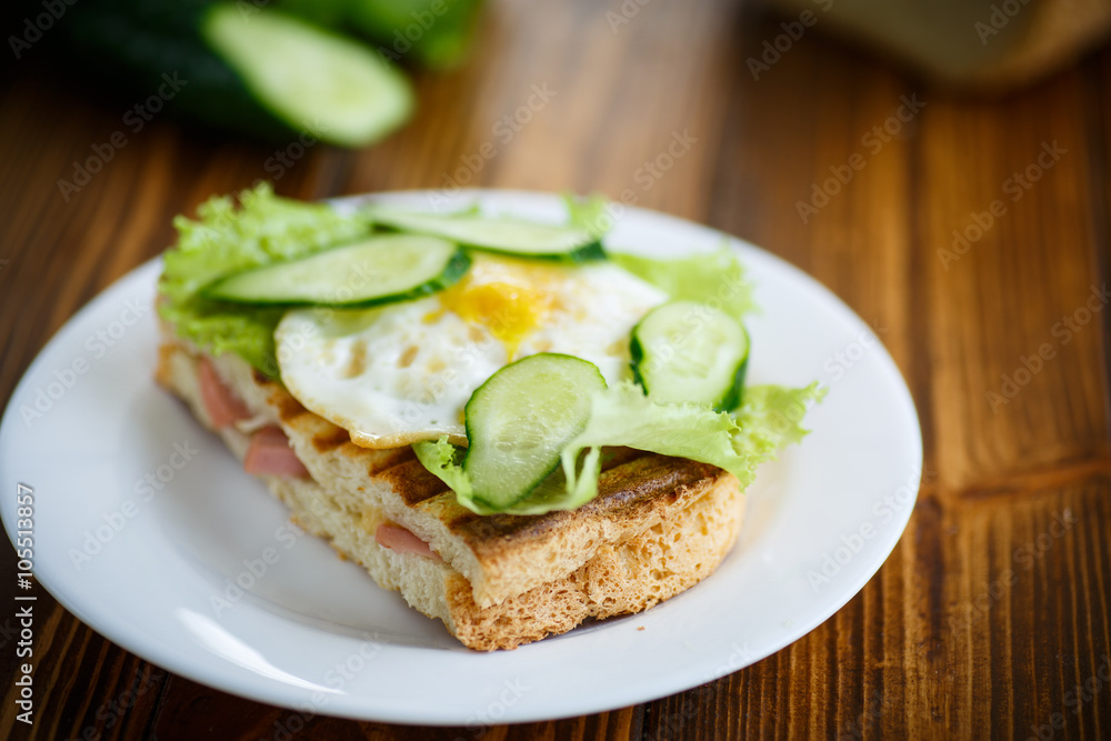 sandwich with sausage, cheese, lettuce and eggs