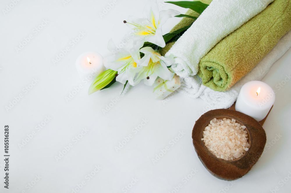 Beautiful spa composition with lily flowers, towels, soap, bath salt and candles