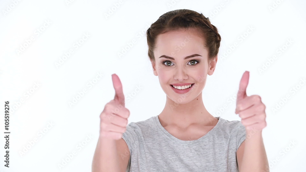 Happy positive smiling woman shows the thumbs-up looking in camera on white background Happy positive smiling woman shows the thumbs-up looking in camera on white background