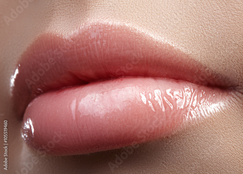 Fotografie Close-up beautiful female lips with bright lipgloss makeup