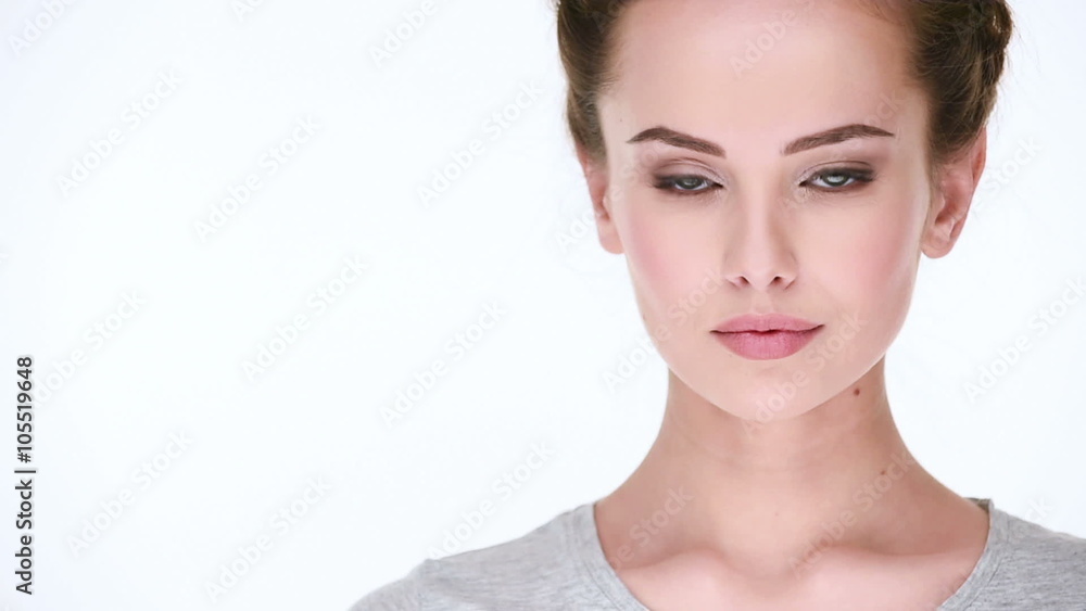 Calm beautiful Woman without emotions turns, looks and posing before camera over white background Calm beautiful Woman without emotions turns, looks and posing before camera over white background