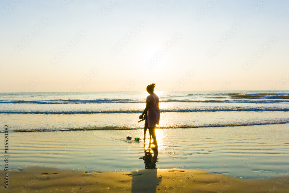 Happy single mom family silhouettes on beach Happy single mom family silhouettes on beach