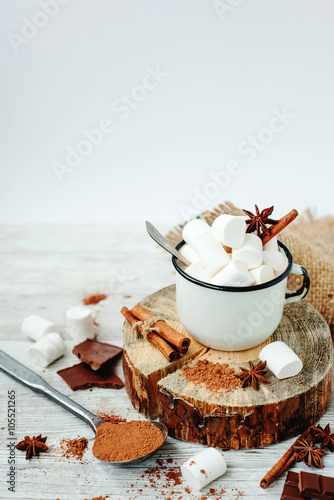 delicious winter hot drink cocoa with marshmallow   cinnamon   chocolate   spices and milk on a white wooden background
