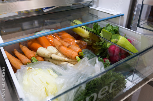 Open fridge filled with vegetables