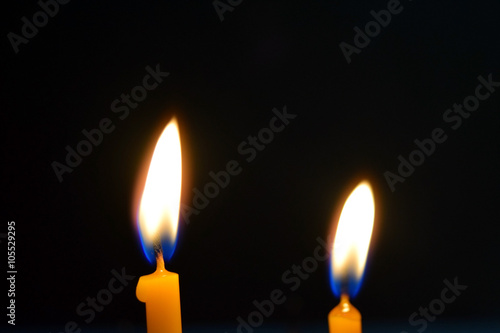 Close up view of the candles burning brightly in the dark.