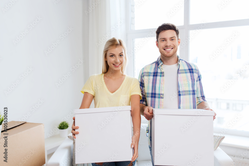 smiling couple with big boxes moving to new home smiling couple with big boxes moving to new home