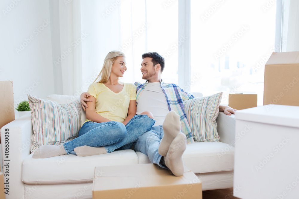 happy couple with big cardboard boxes at new home