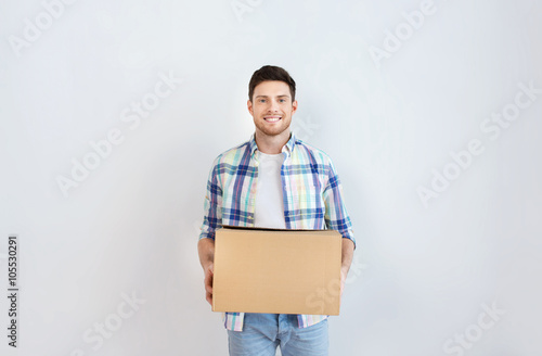 smiling young man with cardboard box at home