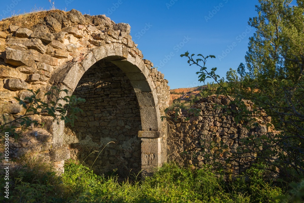 Arco de Piedra en restos de una boveda -  Ruinas de una antigua ermita llena de maleza y vegetacion. Restos de un arco y parte de los muros de la bóveda