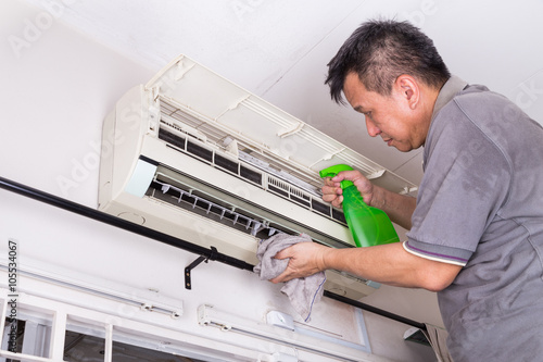 Series of technician servicing the indoor air-conditioning unit. Spraying chemicals.