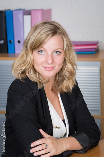 Young businesswoman smiling at camera at her desk