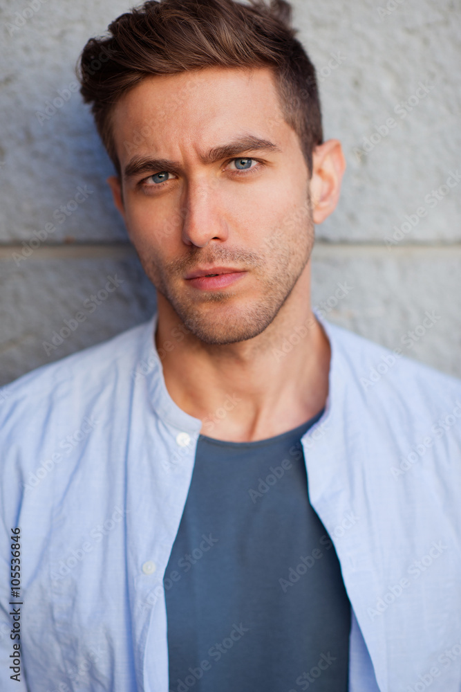 Closeup portrait of a handsome young man standing outside