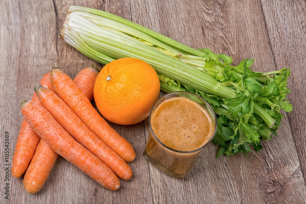 Blended orange smoothie with ingredients on wooden table Blended orange smoothie with ingredients on wooden table