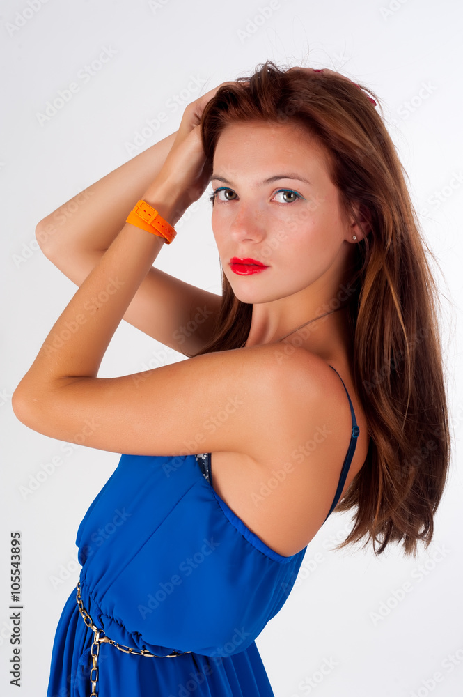 Attractive red-haired girl with freckles wearing blue dress over white background Attractive red-haired girl with freckles wearing blue dress over white background