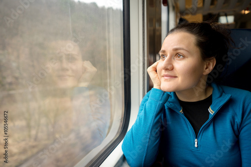 Portrait of young woman traveling by a train.