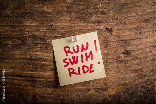 run swim ride! - motivation paper note on wood noticeboard