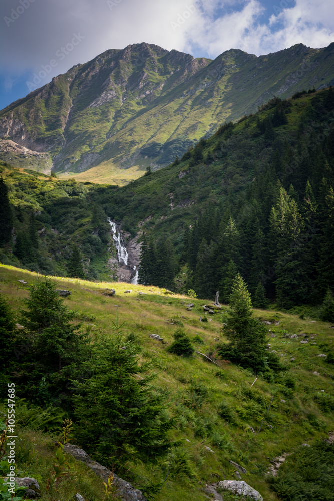 Beautiful waterfall in the scenery of green mountains in Romania