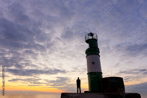 Man and .lighthouse on the sunrise ..