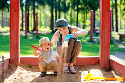 Canvas Print Mom plays with the child in a sandbox