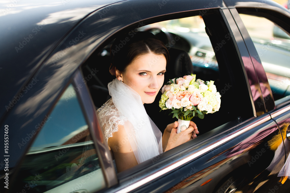 Close up portrait of pretty bride in car window.