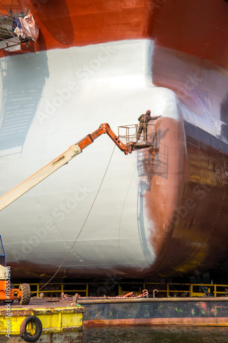 Painting the hull of the ship at the dock during the renovation in Gdansk Repair Shipyard