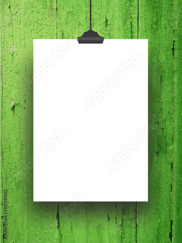 Close-up of one hanged blank frame with clip against green painted wood