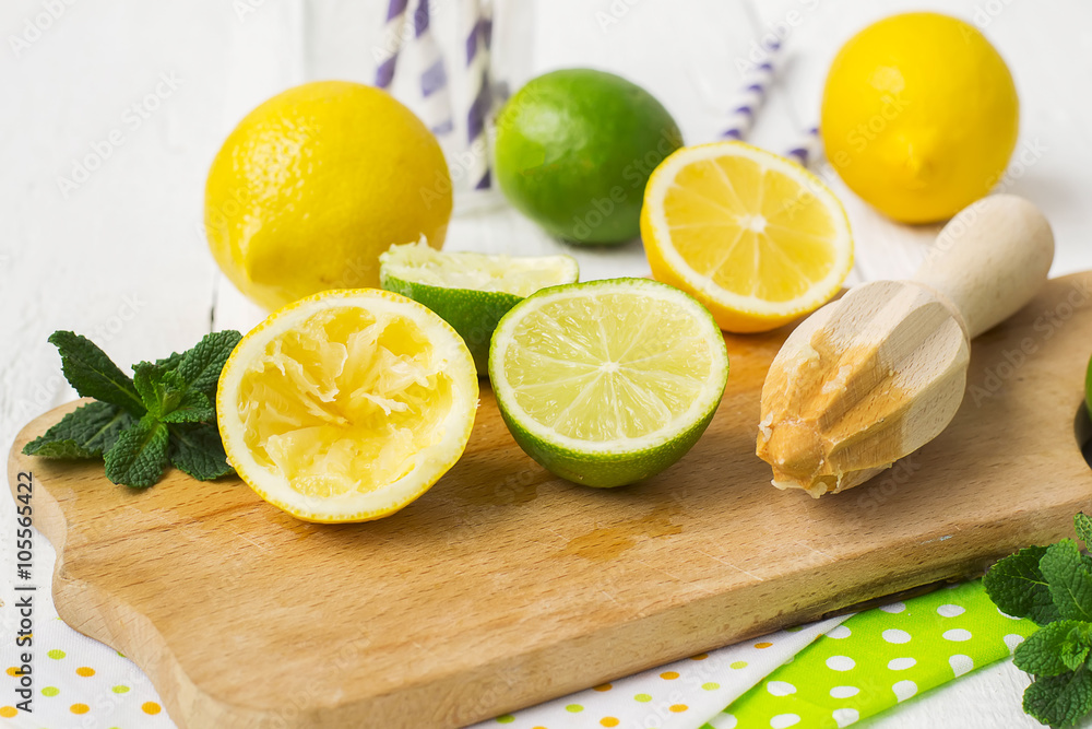 Lemons, limes, mint cocktail preparation on a wooden background Lemons, limes, mint cocktail preparation on a wooden background