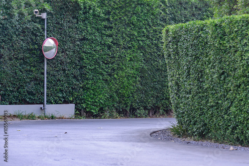 Traffic convex mirror with security camera at street corner.