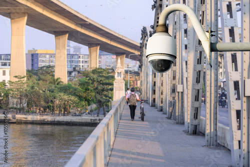 Security camera monitoring events at walk path on bridge in city