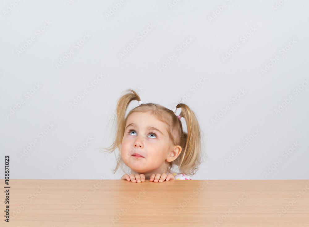 Little girl in casual clothes looking up and thinking