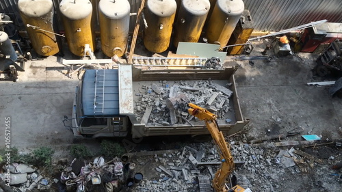 backhoe loader lifting the concrete waste to a truck