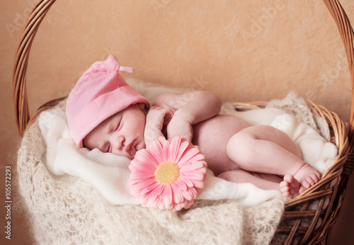 Newborn baby girl in hat with flower