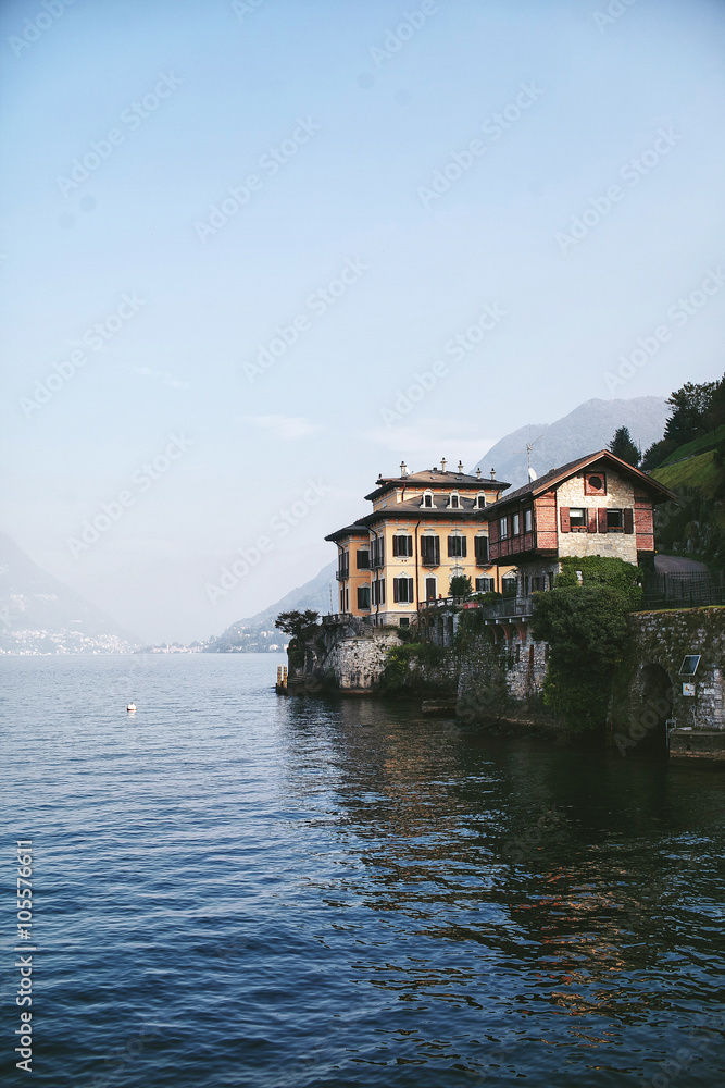 view from the water to the house on the shore of a mountain lake Como