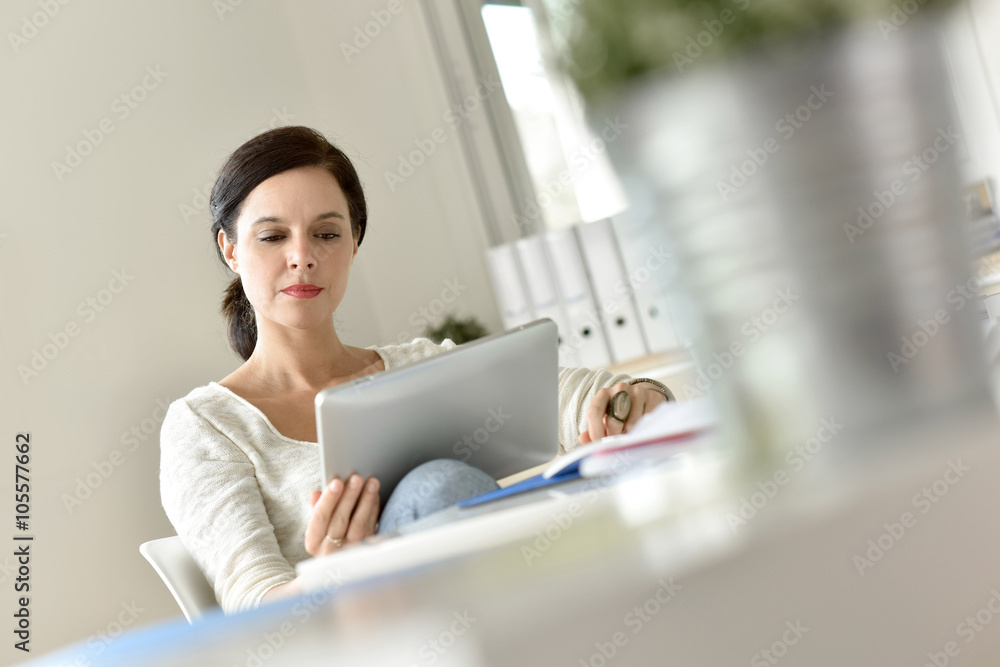 Businesswoman in office working on digital tablet Businesswoman in office working on digital tablet